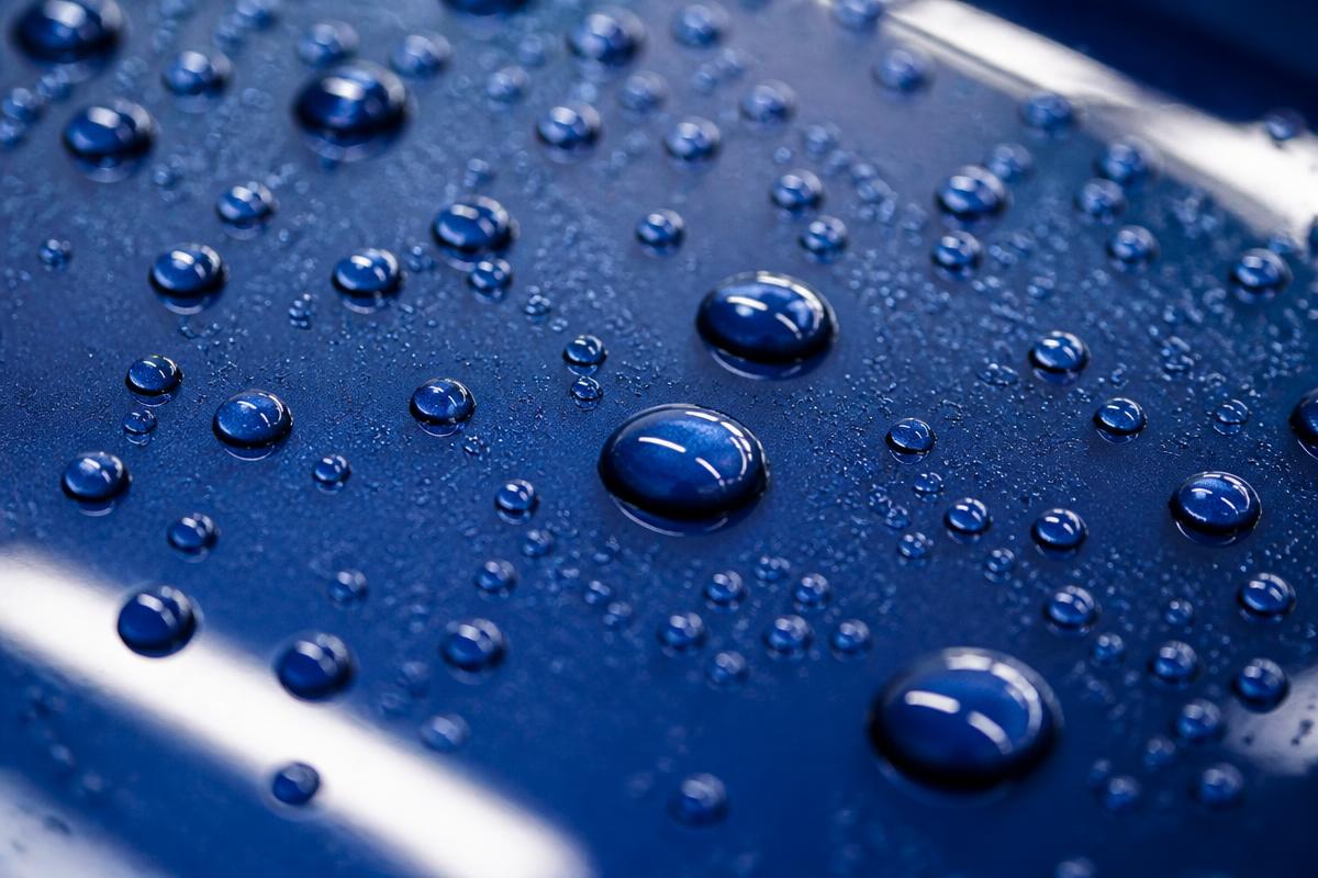 Water beading on a ceramic coated blue car panel
